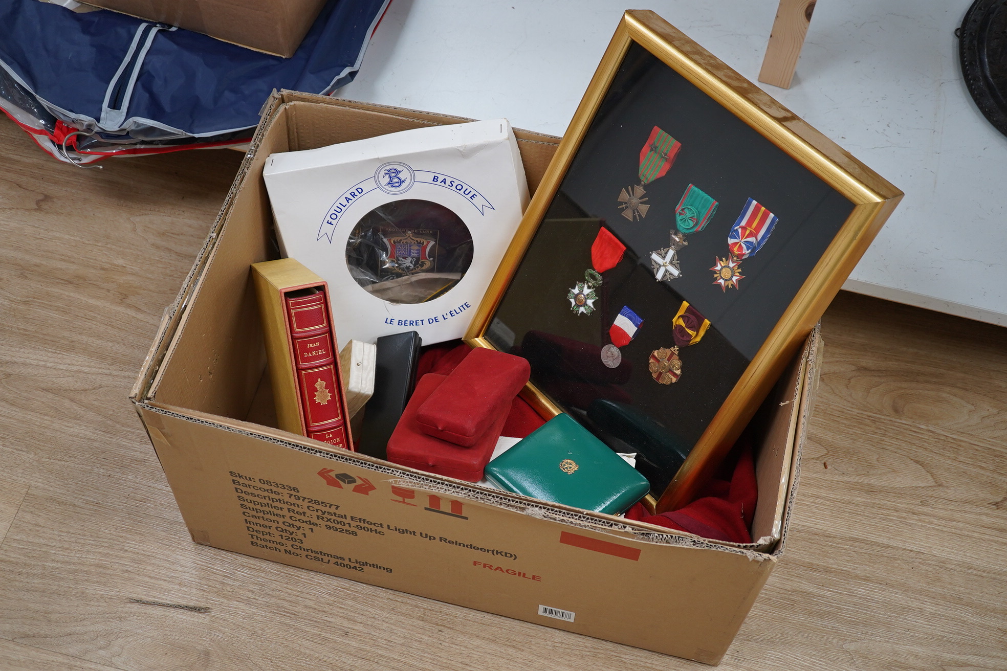 A framed medal group; Legion D'Honneur France, a British Cross, Italian order of Merit and Croix De Guerre with related book; La Legion d’Honneur by Jean Daniel, plus some related paperwork, three related medal miniature